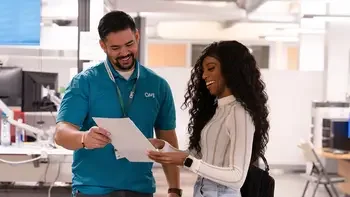 Staff helping a student, showing them a paper