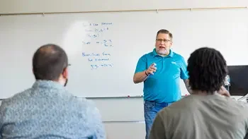 Instructor teaching students at the front of a classroom