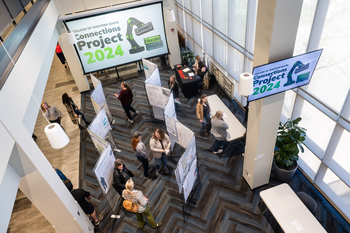 Connections Conference event from the third floor looking down on people looking at projects.