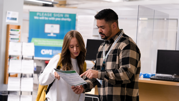 Student receiving help at One Stop by a staff member