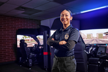 Law Enforcement student standing in front of driving simulator