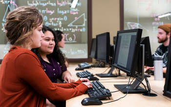 Tutor helping students in computer lab