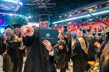 student at Commencement holding a diploma