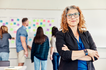 Instructor in classroom with students in background