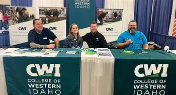 Representatives sit behind a booth sharing information