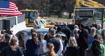 CWI President Gordon Jones speaks to an audience outdoors at a ceremonial event.
