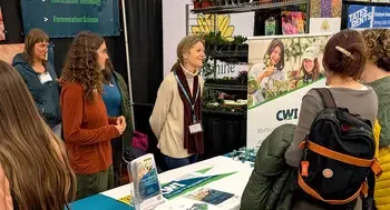 A group of people stand behind a booth at a tradeshow.