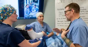 Students learn nursing skills from an instructor.