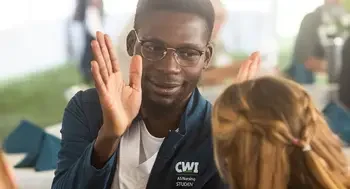 A nursing student gives a "high five" to a donor during a luncheon.