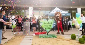 People celebrate the unveiling of a new art installation on campus with confetti cannons.