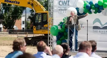 A speaker addresses an audience at a groundbreaking ceremony.