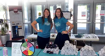 Student Affairs staff handing out CWI swag during a Welcome Picnic for students