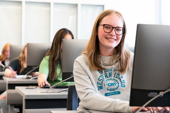 Student typing at a computer.
