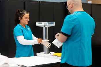 Medical Assistant student putting on gloves
