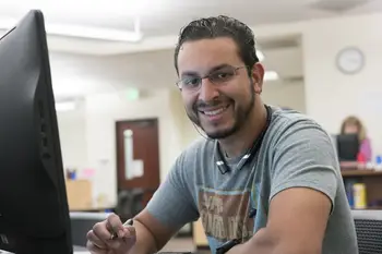 Person with glasses sitting at a computer