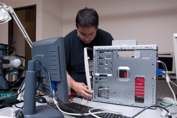 Student working on the insides of a computer tower