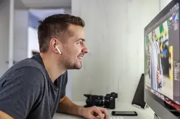 Student editing photos on a desktop computer at a desk