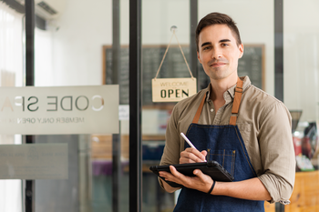 Man standing in front of a store with an open sign