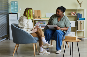 Social worker talking to patient in office
