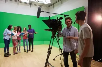Media arts students recording a video of a group of students with a green screen