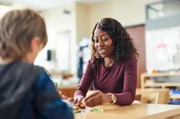 Elementary teacher helping a student.