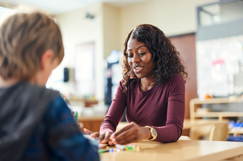 Elementary teacher helping a student.