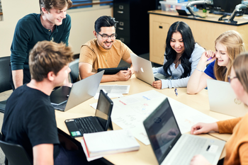 Group of students working with a teacher.