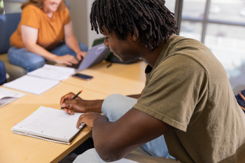 Student writing in notebook.