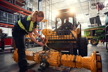 Students working on a piece of heavy equipment.
