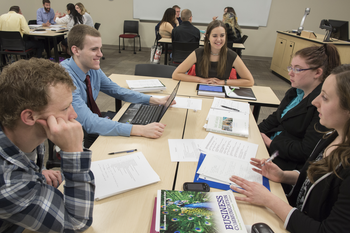 Classroom of CWI students conversing at various tables