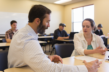 Instructor having a discussion with student in classroom