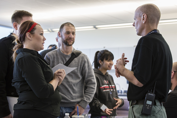 Group of students talking to an officer in a classroom