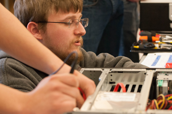 Student looking at the insides of a computer
