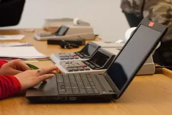 Hands navigating on a laptop computer