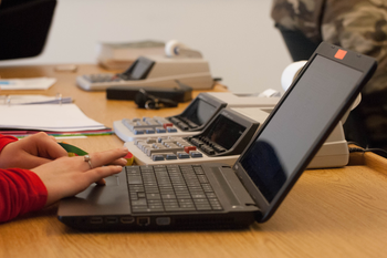 Hands navigating on a laptop computer