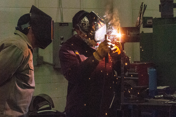 Two welders working on project in lab