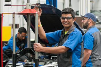 CWI students in an auto technology lab and one is looking at the camera