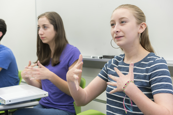 Students practicing signing in a classroom
