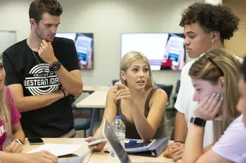 Group of students talking at table in classroom
