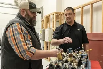 Plumbing instructor working with student