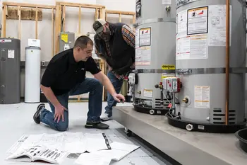 Plumbing instructor and student examining a water heater