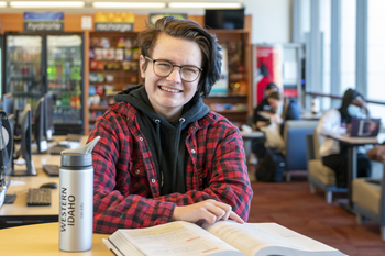 Student reading a book and smiling.