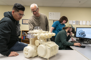 Students looking at a 3D print on a desk
