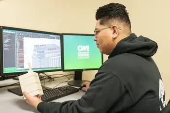 CWI student sitting at a computer studing drafts