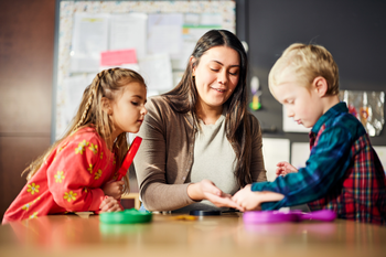 Student working with two young children at a table