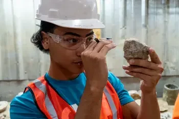 Mining student examining rock.