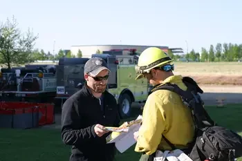 Instructor and student talking outside next to Wildland Fire truck
