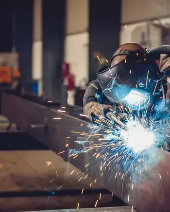 Welder repairing pipe