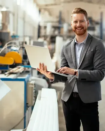 Manager holding a laptop in a warehouse