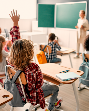Classroom with young kids raising their hands